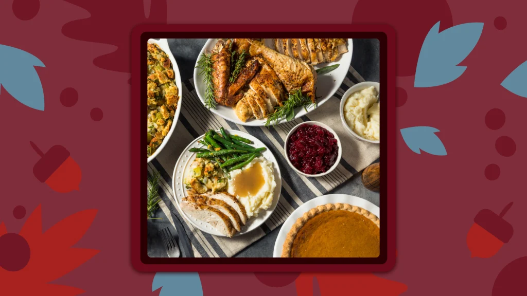 A traditional Thanksgiving dinner table with turkey, mashed potatoes, pumpkin pie and cranberry sauce on plates.